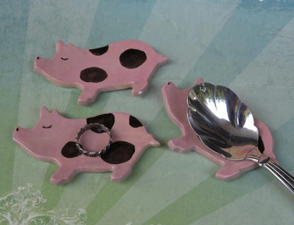 Pig ring holder. ONE Piglet teaspoon rest. Teaspoon rest. Coffee spoon rest. Chopstick rest. Teeny trinket dish. Pill holder.